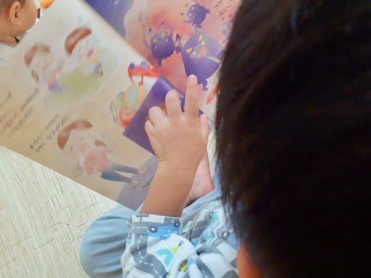 アトピッグの絵本を読む2歳児